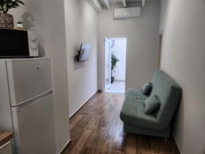 a living room with a green couch and a refrigerator at Pinedo Playa Holiday in Valencia