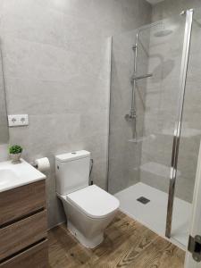 a bathroom with a toilet and a glass shower at Pinedo Playa Holiday in Valencia +4 photos