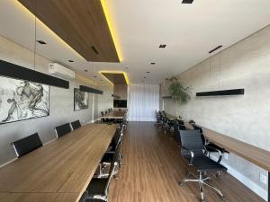 a conference room with long tables and chairs at Studio Harmonia Ar Cond/Centro/Piscina/Academia in Juiz de Fora +15 photos