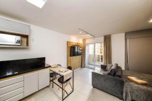 a kitchen and living room with a couch and a table at Stúdio Elegance Central - Av Itamar Franco in Juiz de Fora