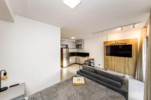 a living room with a couch and a kitchen at Stúdio Elegance Central - Av Itamar Franco in Juiz de Fora