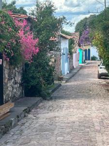 a cobblestone street in a village with flowers at Bendita Pausa-Igatu in Igatu