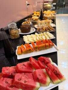 a buffet with many different types of fruit on plates at Plaza Hotel in Mineiros