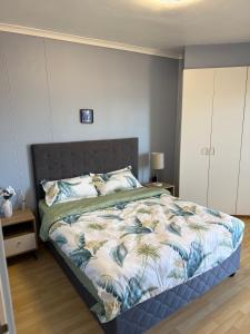 a bedroom with a bed with a floral bedspread at Cozy Apartment with Table Mountain and beach views in Cape Town