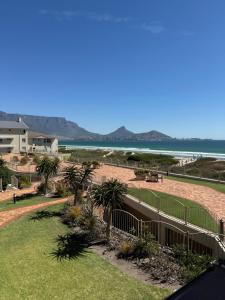 a view of the beach from the balcony of a resort at Cozy Apartment with Table Mountain and beach views in Cape Town