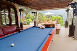 a pool table in an outdoor area with a table and chairs at Hotel Campestre Rancho La Lechería in Cali