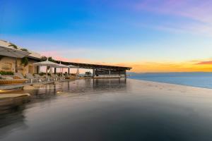 a beach with chairs and a building and the water at UDARA - Beachfront Condos in Golden Zone with Rooftop in Bucerías +82 photos