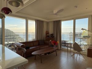 a living room with a couch and a table and some windows at Surf Resort Jukdo Alive in Yangyang