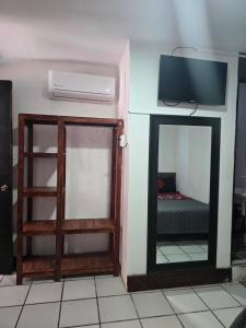 a room with a tv and a door with a mirror at Alojamiento amplio para descanso H3 in Veracruz