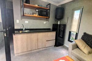 a kitchen with a sink and a refrigerator at Rincón Sereno Tunuyán Cabaña 2 in Tunuyán