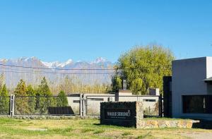 a sign in front of a building with mountains in the background at Rincón Sereno Tunuyán Cabaña 2 in Tunuyán
