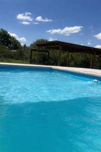 a large blue swimming pool with a gazebo at Rincón Sereno Tunuyán Cabaña 2 in Tunuyán +10 photos