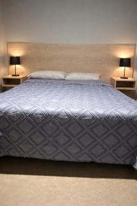 a large bed with two lamps on two tables at Rincón Sereno Tunuyán Cabaña 2 in Tunuyán