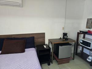 a bedroom with a bed and a desk with a microwave at Habitación 2 climatizada cerca de IMSS UMAE in Veracruz
