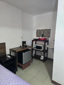 a room with a bed and a desk and a microwave at Habitación 2 climatizada cerca de IMSS UMAE in Veracruz +6 photos