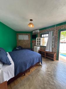 a bedroom with a blue bed and green walls at Pousada Ventoria in Canguaretama