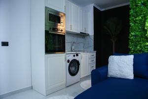 a kitchen with a washing machine and a microwave at Amiri Lux Suites in Shkodër