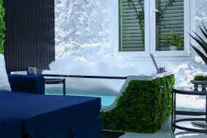 a room with a snow covered tub with a table and chairs at Amiri Lux Suites in Shkodër
