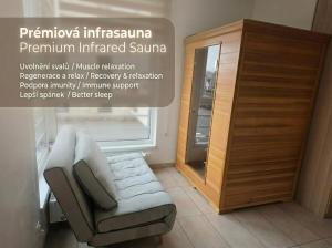 a room with a chair and a mirror and a cabinet at Apartmán Berenika in Vrchlabí
