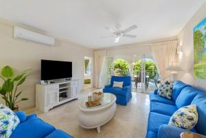 a living room with blue couches and a tv at Royal Apartment 223 in Saint James