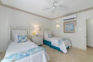 a bedroom with two beds and a ceiling fan at Royal Apartment 223 in Saint James +21 photos