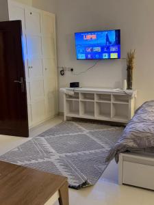 a bedroom with a bed and a tv on the wall at Separate studio jimi in Al Ain +3 photos