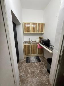 a small kitchen with wooden cabinets and a sink at Separate studio jimi in Al Ain