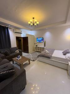 a living room with a bed and a couch at Separate studio jimi in Al Ain