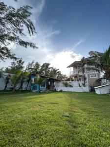 a house with a lawn in front of it at Pousada Ventoria in Canguaretama