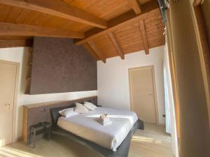 a bedroom with a bed with white sheets and wooden ceilings at Villa Fiesta in Oggiono