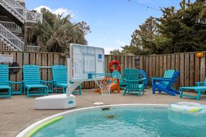 a pool with chairs and a sign in a yard at OPM Coastal Retreat in Salvo