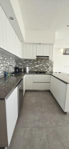 a kitchen with white cabinets and a sink at Luxury Condo Residencial Area Close to Everything in Puerto Vallarta