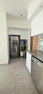 a kitchen with a stainless steel refrigerator and a stove at Luxury Condo Residencial Area Close to Everything in Puerto Vallarta