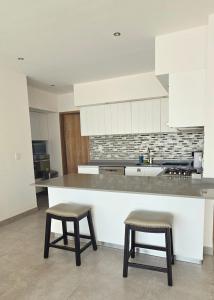 a kitchen with a counter and two stools in it at Luxury Condo Residencial Area Close to Everything in Puerto Vallarta