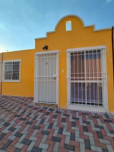 a yellow building with two doors and windows at Casa Luna TX in Tequisquiapan