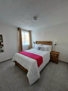 a bedroom with a large bed with a red blanket at Casa Luna TX in Tequisquiapan