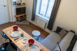 a living room with a table and a couch at La petite cour in Beaune