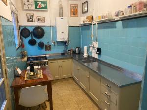 a kitchen with blue tiled walls and a counter top at La Santiaga Sólo para chicas in Córdoba