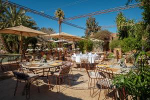 an outdoor dining area with tables and chairs and umbrellas at Villa Nour in Marrakesh