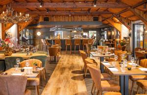 ein Restaurant mit Holzdecken, Tischen und Stühlen in der Unterkunft Chalet Descansar op de Veluwe in Beekbergen