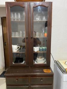 a wooden cabinet with dishes inside of it at Barra in Barra Velha