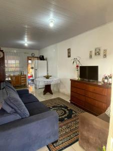 a living room with a blue couch and a tv at Barra in Barra Velha