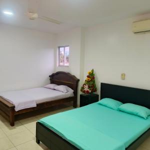 a bedroom with two beds and a christmas tree at Hotel BSJ Neiva in Neiva +107 photos
