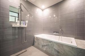 a bathroom with a bath tub and a shower at Daegu Innovation City Stay22 in Panyawŏl-yŏk +17 photos