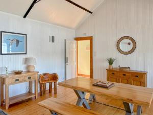 a dining room with a wooden table and a mirror at The Heron in Ardentinny