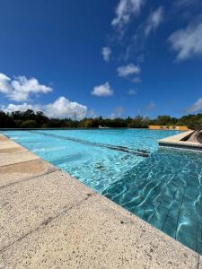 a swimming pool with blue water and trees in the background at Casa de campo en Punta Ballena in Punta del Este