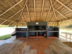 a large outdoor kitchen under a large roof at Casa de campo en Punta Ballena in Punta del Este
