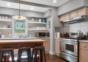 a kitchen with a counter and stools in it at Berkshire House Stay in Lee