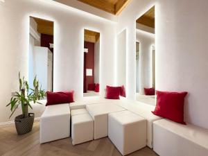 a living room with red pillows and white seats at La Divina - free parking - in Tropea