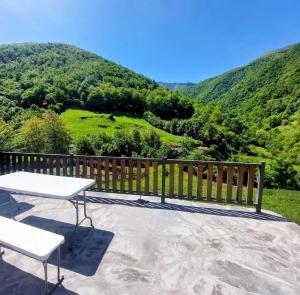a table and chairs on a balcony with a view of a mountain at Casa Nayala in Río Aller